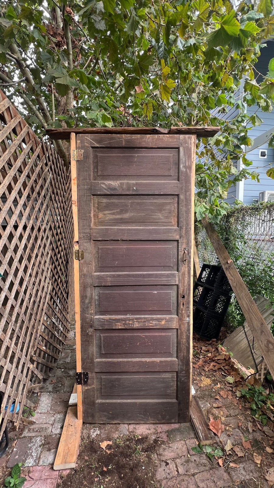 Reclaimed wooden door mounted in a freestanding frame in my backyard