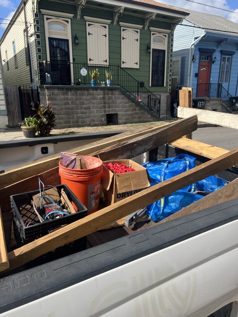 Pickup truck bed loaded with reclaimed wood, siding, and building materials